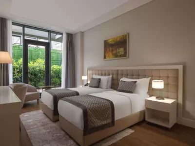 a hotel room with two beds and a window at Movenpick Living Istanbul West in Istanbul