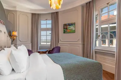 a bedroom with a bed with white pillows and a chandelier at Orientbank Hotel Istanbul, Autograph Collection in Istanbul