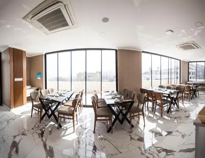 a dining room with tables and chairs and large windows at KAR BEYAZ HOTEL BURSA in Bursa