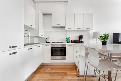 a kitchen with white cabinets and a table and chairs at NOA - Tatar Beyi 18 in Istanbul