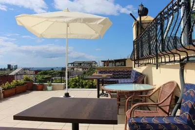 a patio with tables and an umbrella on a balcony at Hotel Peninsula in Istanbul