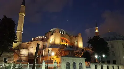 a large building with a mosque at night at Hotel Peninsula in Istanbul