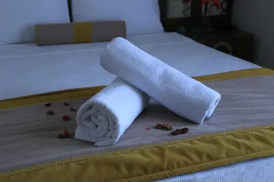 a rolled up towel on a bed with some coffeeumbs at Burçman Hotel Vişne in Yıldırım