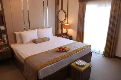 a hotel room with a bed with a bowl of fruit on it at Burçman Hotel Vişne in Yıldırım