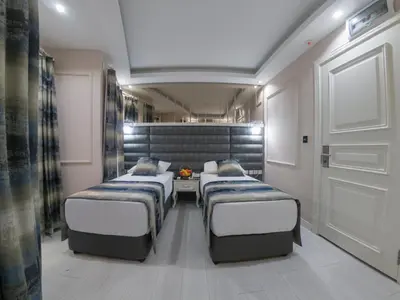 a room with three beds and a table in it at Crowned Hotel in Istanbul