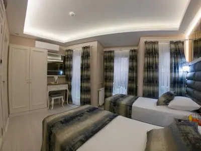 a hotel room with two beds and a desk at Crowned Hotel in Istanbul