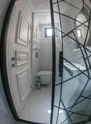 a white bathroom with a door and a toilet at Crowned Hotel in Istanbul