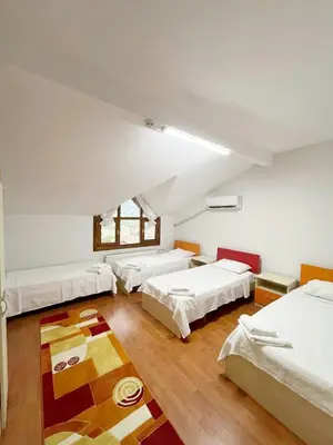 a room with three beds and a table in it at Sapanca Albar Konaklama in Sapanca