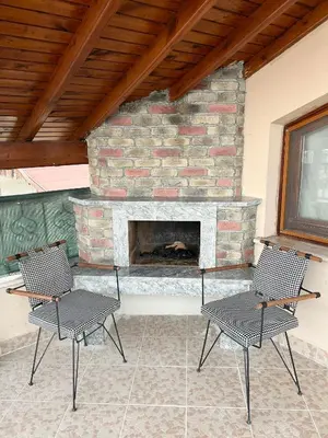 a patio with two chairs and a brick fireplace at Sapanca Albar Konaklama in Sapanca