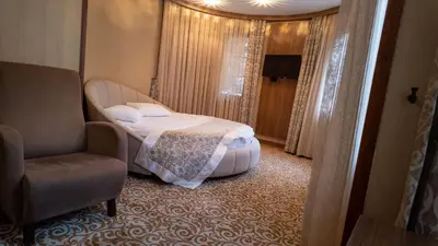 a bedroom with a bed and a chair in a room at Cesmeli Konak Hotel Silivri in Silivri