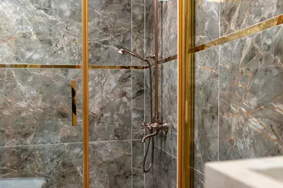 a shower in a bathroom with a stone wall at The Ottoman in Istanbul