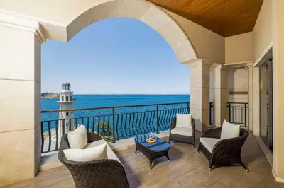 a balcony with a view of the ocean and a lighthouse at Birun Ada Hotel in Istanbul