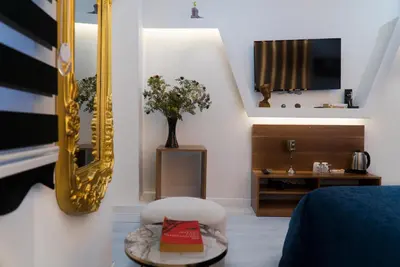 a bedroom with a bed and a mirror and a chair at The Havana Residence in Istanbul