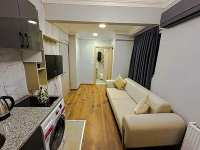 a living room with a couch and a kitchen at Sisli House By Remar Holding in Istanbul