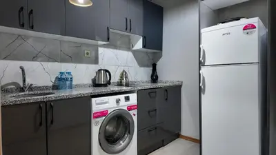 a kitchen with a white refrigerator and a washing machine at Sisli House By Remar Holding in Istanbul