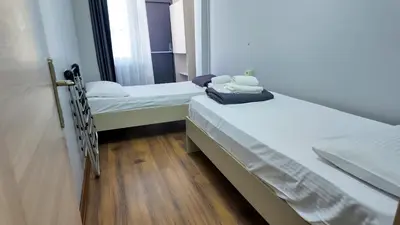 two beds in a small room with wooden floors at Sisli House By Remar Holding in Istanbul