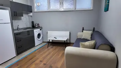 a living room with a couch and a kitchen at Sisli House By Remar Holding in Istanbul