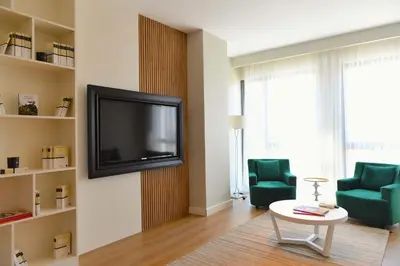 a living room with a tv and two green chairs at G Tower Furnished Apartment Rentals in Istanbul