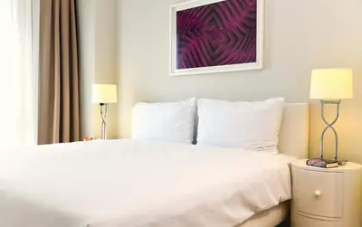 a white bed in a hotel room with two lamps at G Tower Furnished Apartment Rentals in Istanbul