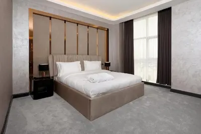a bedroom with a large bed with white sheets at Aileena Hotel & Villas in Kartepe