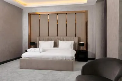 a bedroom with a large white bed and a chair at Aileena Hotel & Villas in Kartepe