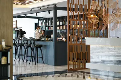 a woman standing at a bar in a restaurant at Aileena Hotel & Villas in Kartepe