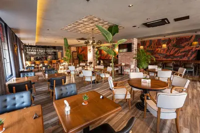 a restaurant with tables and chairs and a bar at Levor Hotel in Bursa
