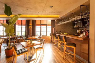 a restaurant with wooden tables and chairs and a bar at Levor Hotel in Bursa
