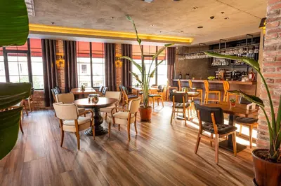 a restaurant with wooden tables and chairs and plants at Levor Hotel in Bursa