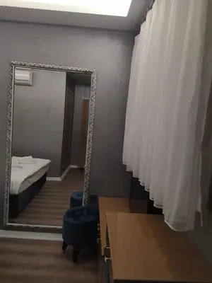 a mirror in a room with a bed and a chair at BoNaMi Hotel in Istanbul