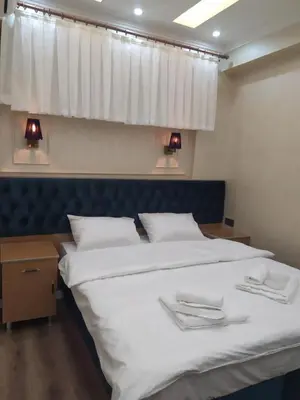 a bedroom with a bed with white sheets and a window at BoNaMi Hotel in Istanbul