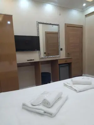 a bathroom with two white towels on a bed with a mirror at BoNaMi Hotel in Istanbul