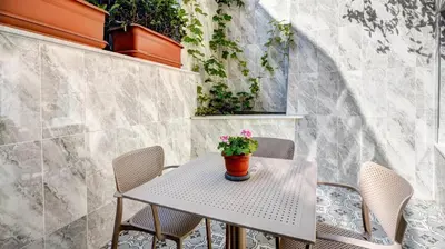 a table and chairs with a potted plant on it at SEVEN ROSES APART HOTEL in Istanbul