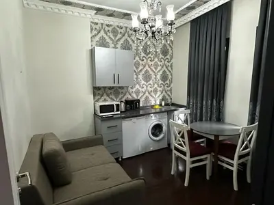 a living room with a couch and a table and a kitchen at SEVEN ROSES APART HOTEL in Istanbul