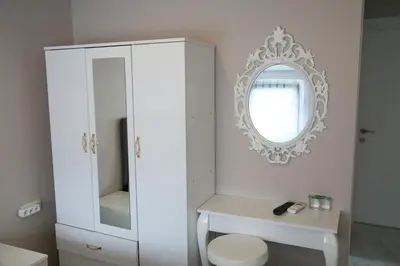 a white bathroom with a white cabinet and a mirror at ATİK HOTEL in Istanbul