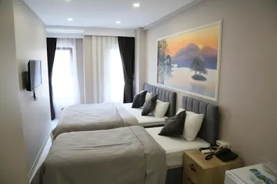 a hotel room with two beds and a painting on the wall at ATİK HOTEL in Istanbul