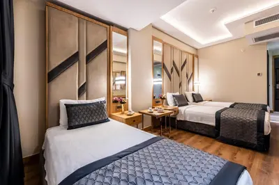 a hotel room with two beds and a table at Endican Sultanahmet Hotel in Istanbul