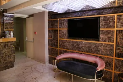 a room with a tv and a bench in front of a wall at The Grand Tower Hotel in Istanbul