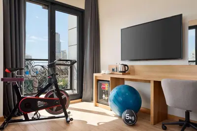 a room with a desk with a television and a chair at Tryp by Wyndham Istanbul Atasehir in Istanbul