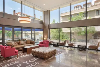 a lobby with a couch and chairs and windows at Tryp by Wyndham Istanbul Atasehir in Istanbul