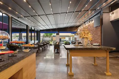 a restaurant with tables and chairs and a brick wall at Tryp by Wyndham Istanbul Atasehir in Istanbul