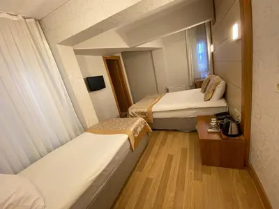a small hotel room with two beds and a table at Timeks Hotel Sultanahmet in Istanbul