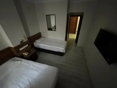 a hotel room with two beds and a mirror at Altinnal Hotel in Kocaeli