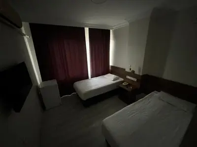 a hotel room with two beds and a window at Altinnal Hotel in Kocaeli