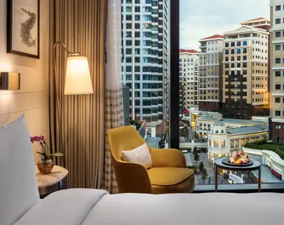 a hotel room with a bed and a chair and a window at Address Istanbul in Istanbul