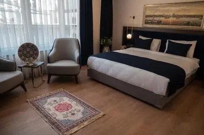 a bedroom with a large bed and a chair and a couch at Nevi Hotel & Suites Istanbul Taksim in Istanbul