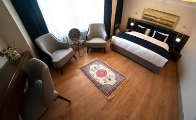 a bedroom with a bed and a couch and a chair at Nevi Hotel & Suites Istanbul Taksim in Istanbul