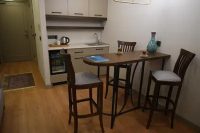 a kitchen with a wooden table and chairs and a counter at Nevi Hotel & Suites Istanbul Taksim in Istanbul