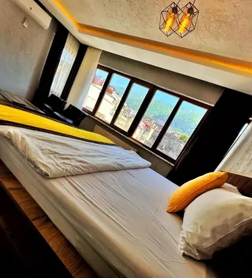 a large bed in a room with windows at Pera Pansiyon in Bursa