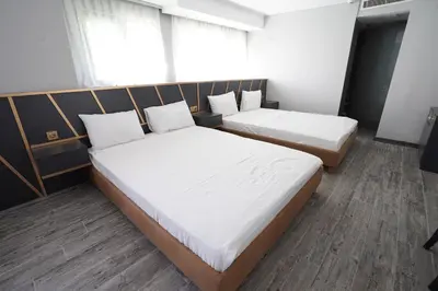 two beds in a room with white sheets at Time Hotel Mecidiyekoy in Istanbul